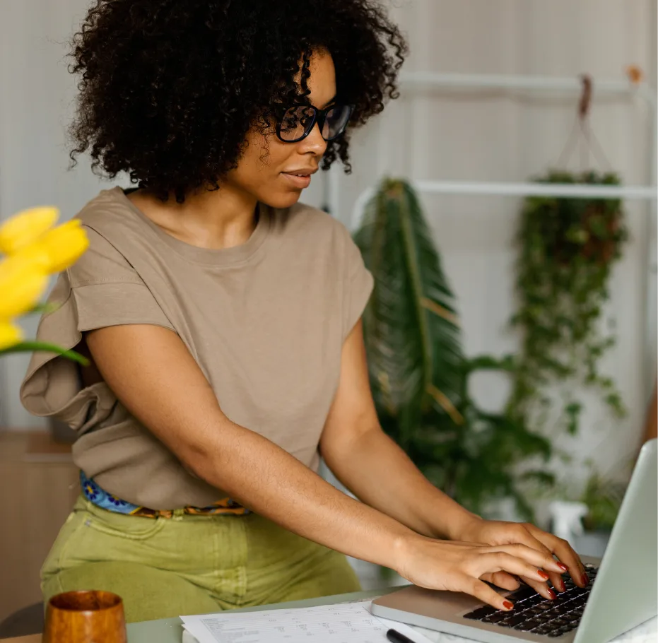 A still of a woman sitting at a desk working on a laptop